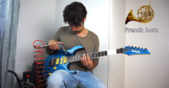 Muž napodobňuje na gitare rôzne hudobné nástroje. Pomáha mu v tom kompresor, ponožka, či bankovky